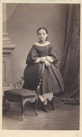 Fillette appuyée sur un fauteuil